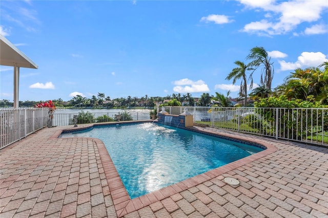 view of swimming pool featuring pool water feature, a water view, and a patio area