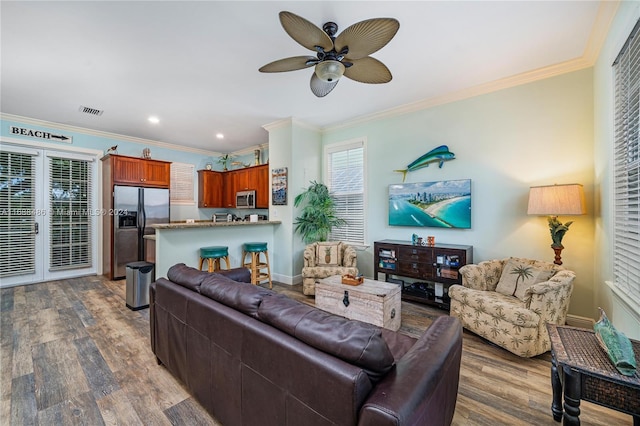 living room featuring ceiling fan, crown molding, and dark wood-type flooring