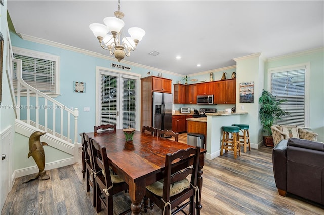 dining area featuring dark hardwood / wood-style flooring, an inviting chandelier, and ornamental molding