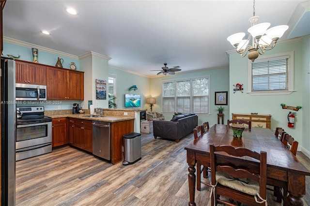 kitchen with ceiling fan with notable chandelier, crown molding, dark hardwood / wood-style floors, kitchen peninsula, and stainless steel appliances