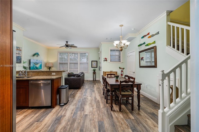 dining area with ceiling fan with notable chandelier, dark hardwood / wood-style flooring, ornamental molding, and sink