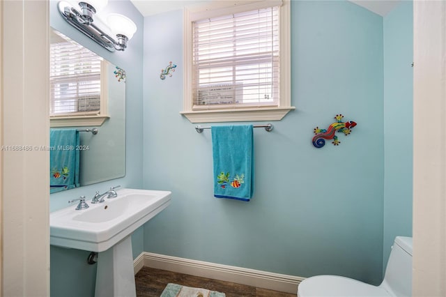 bathroom with toilet, wood-type flooring, and sink