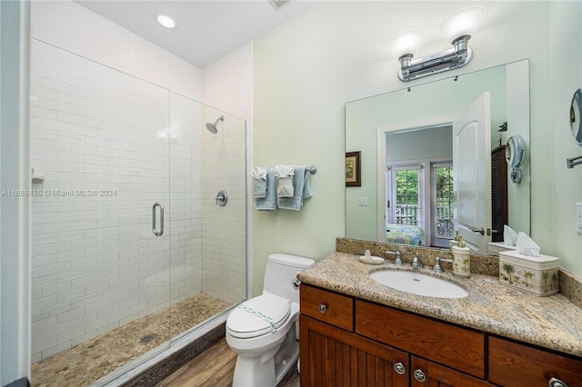 bathroom with wood-type flooring, vanity, toilet, and an enclosed shower