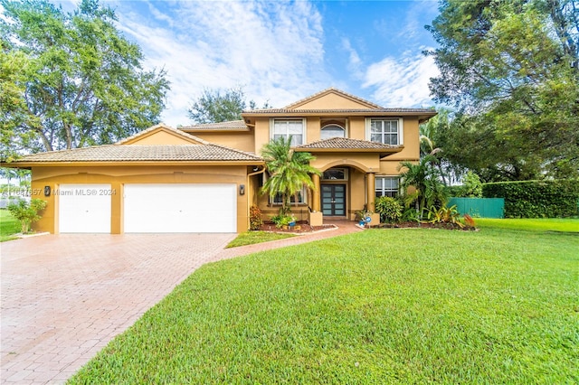 mediterranean / spanish home featuring french doors, a front lawn, and a garage