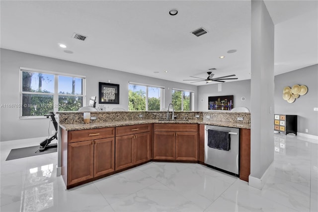 kitchen featuring light stone countertops, dishwasher, ceiling fan, and sink