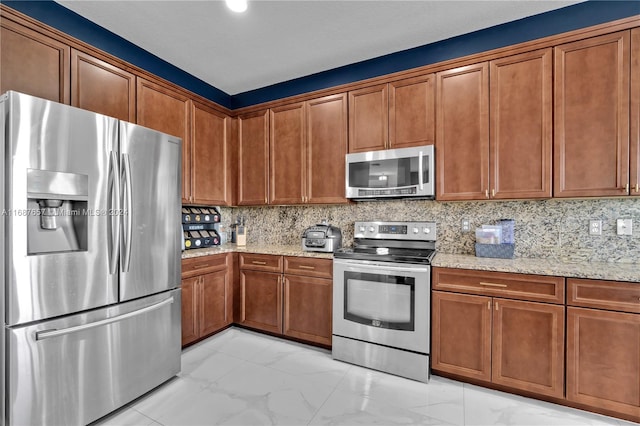 kitchen with tasteful backsplash, light stone countertops, and appliances with stainless steel finishes