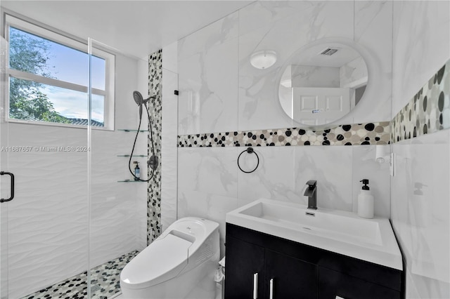 bathroom featuring vanity, toilet, a shower with door, and tile walls