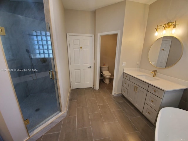 bathroom featuring vanity, an enclosed shower, and toilet