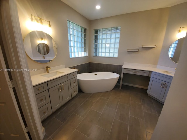 bathroom with a tub and vanity