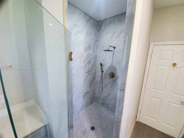 bathroom with a tile shower and tile patterned floors