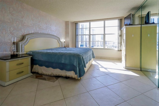 bedroom featuring light tile patterned floors and a textured ceiling