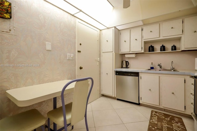 kitchen with light tile patterned floors, stainless steel dishwasher, and sink