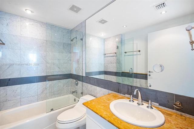 full bathroom with vanity, shower / bath combination with glass door, toilet, tile walls, and tasteful backsplash