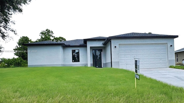 prairie-style home featuring a front lawn and a garage