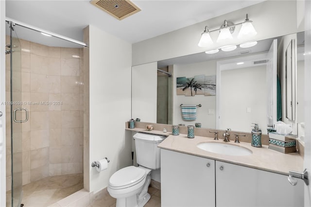 bathroom featuring tile patterned floors, vanity, an enclosed shower, and toilet