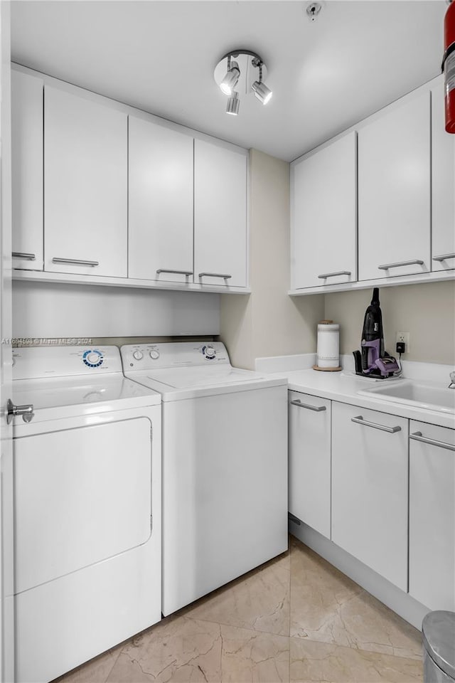 clothes washing area featuring cabinets and washer and dryer