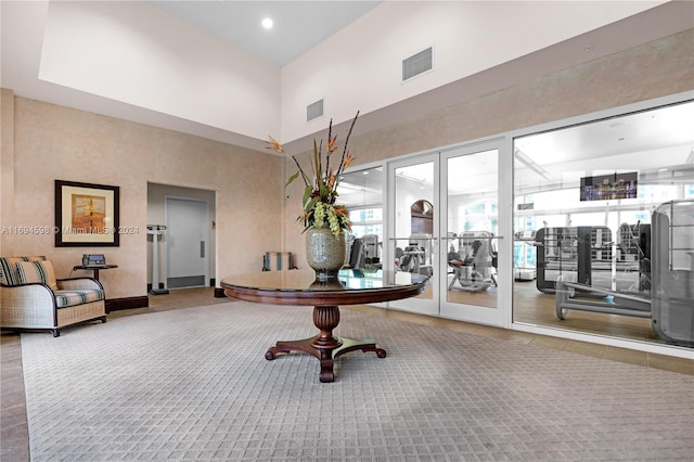 interior space with carpet flooring and a towering ceiling