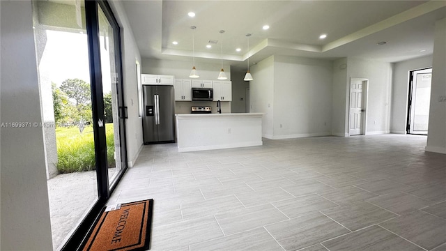 living room featuring a tray ceiling and sink