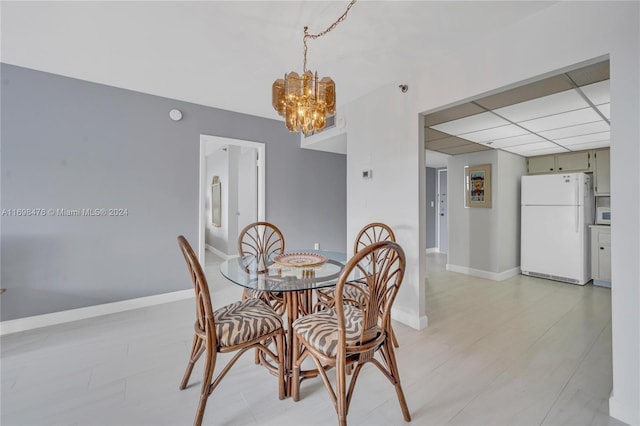 dining space featuring a drop ceiling and a notable chandelier