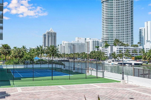 view of tennis court with a water view