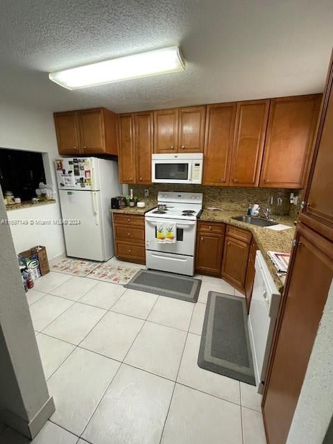 kitchen with light tile patterned flooring, white appliances, sink, and tasteful backsplash