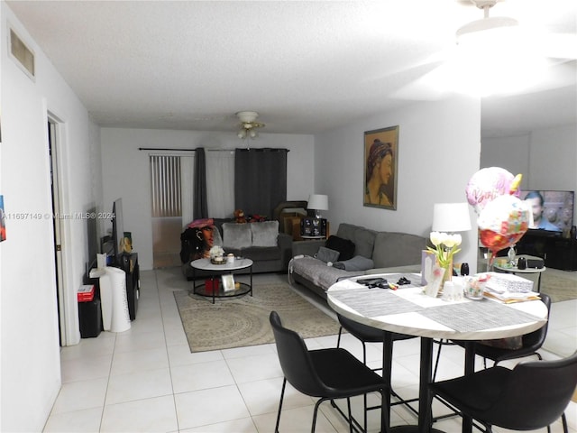 tiled dining area featuring ceiling fan and a textured ceiling