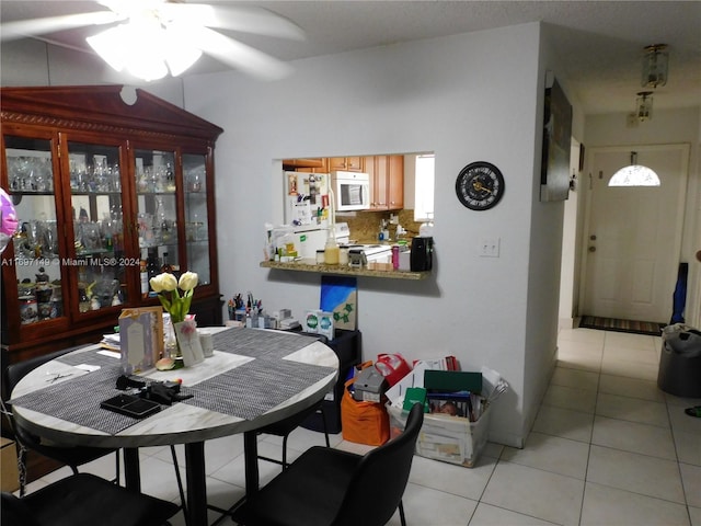 tiled dining area featuring ceiling fan