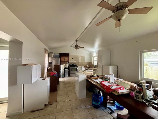 kitchen featuring stainless steel appliances, white cabinetry, lofted ceiling, and light tile patterned flooring