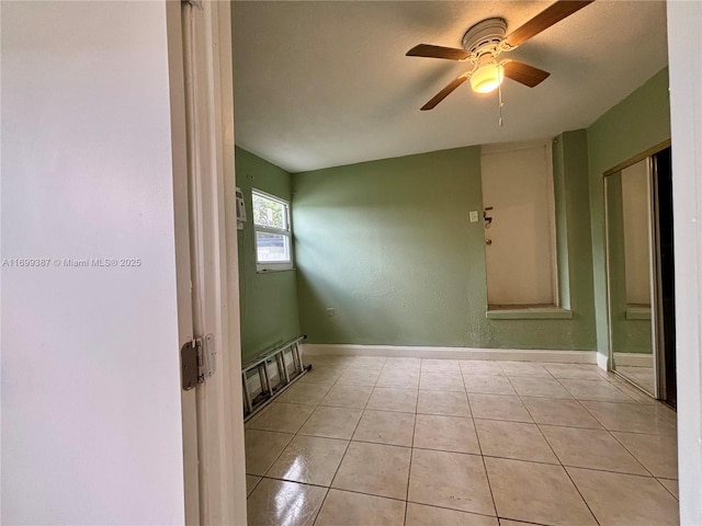 empty room featuring ceiling fan and light tile patterned flooring