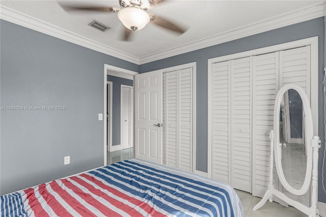 bedroom featuring multiple closets, ceiling fan, and crown molding