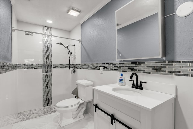 bathroom featuring vanity, toilet, tiled shower, and tile walls