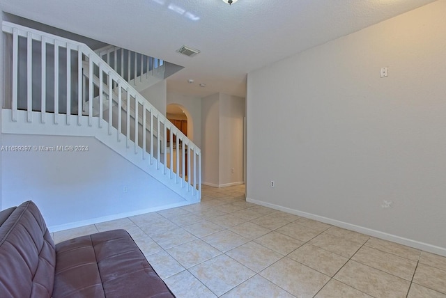 stairs featuring a textured ceiling and tile patterned floors