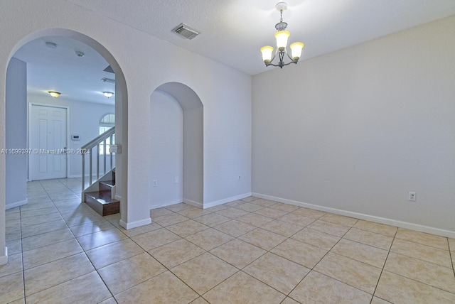 unfurnished room featuring light tile patterned floors and a notable chandelier