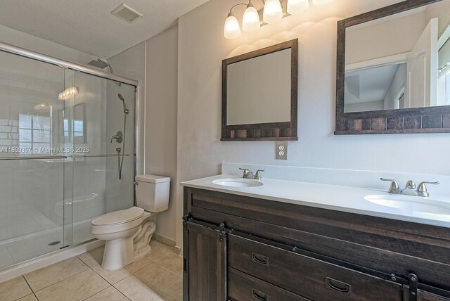 bedroom featuring connected bathroom, ceiling fan, dark wood-type flooring, a tray ceiling, and two closets