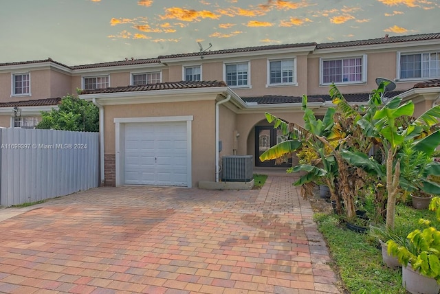 view of front of home featuring central air condition unit and a garage