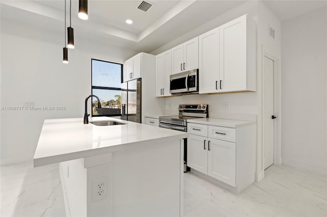 kitchen with a center island with sink, decorative light fixtures, sink, and stainless steel appliances