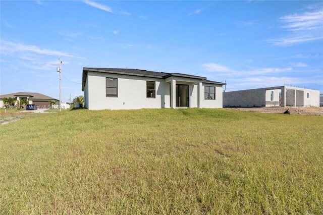 rear view of property featuring a lawn