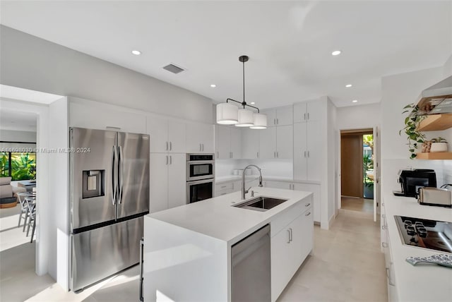 kitchen featuring white cabinetry, sink, an island with sink, decorative light fixtures, and appliances with stainless steel finishes