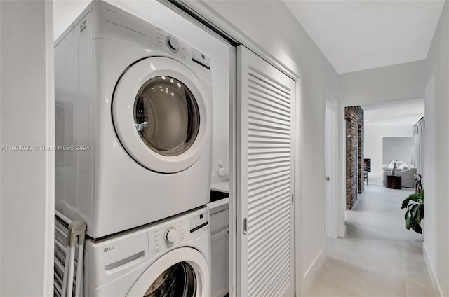 clothes washing area with stacked washing maching and dryer