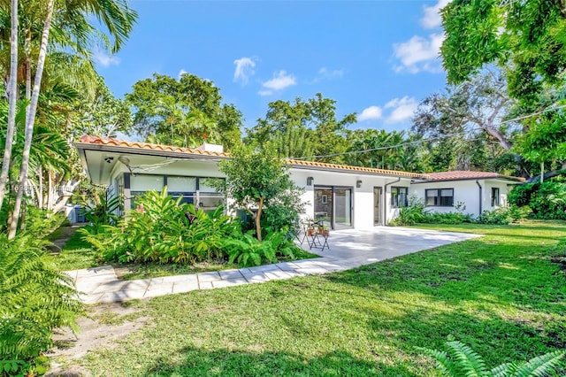 rear view of property featuring a yard and a patio