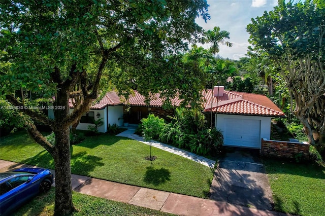 view of front of property with a front yard and a garage