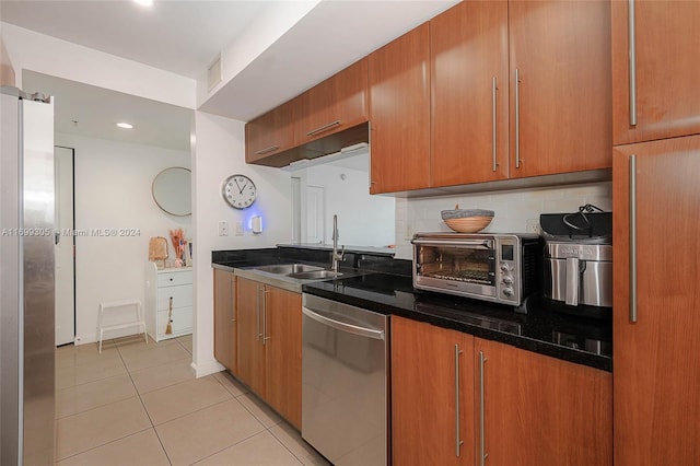 600 W Las Olas Blvd Unit 509S, Fort Lauderdale, FL 33312 - kitchen with appliances with stainless steel finishes, light tile patterned flooring, brown cabinetry, tasteful backsplash, and dark stone countertops