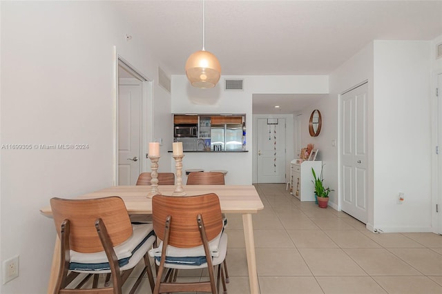 dining area featuring light tile patterned floors and sink