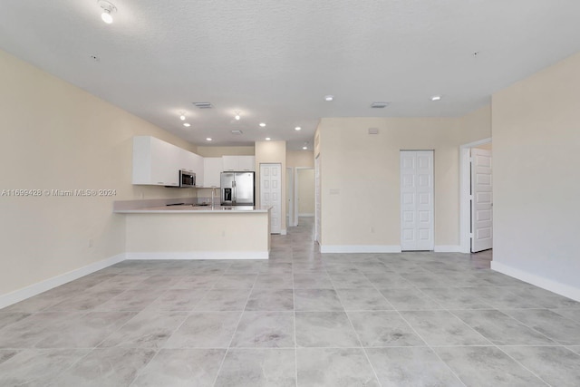 unfurnished living room with light tile patterned flooring and a textured ceiling