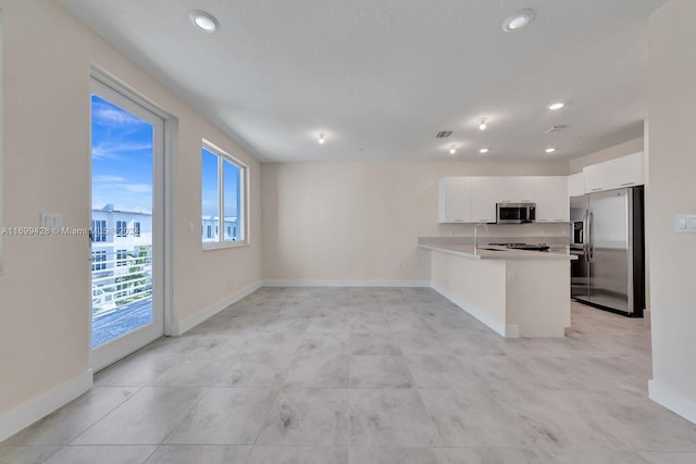 kitchen with kitchen peninsula, white cabinetry, sink, and stainless steel appliances