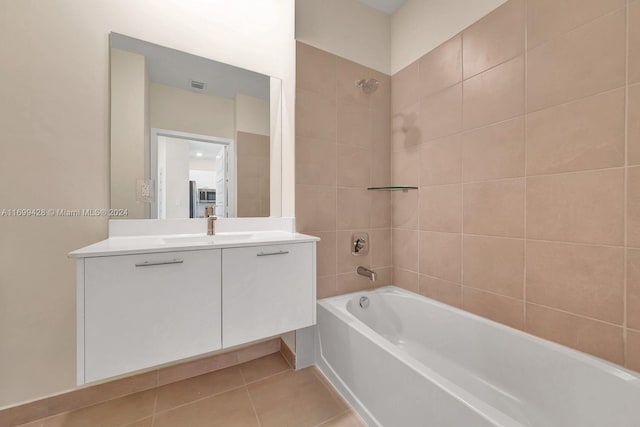 bathroom featuring tile patterned flooring, vanity, and tiled shower / bath combo