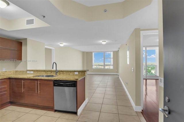 kitchen with sink, light stone counters, stainless steel dishwasher, kitchen peninsula, and light wood-type flooring