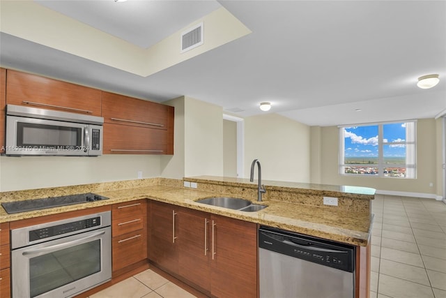 kitchen featuring kitchen peninsula, sink, light tile patterned flooring, and appliances with stainless steel finishes