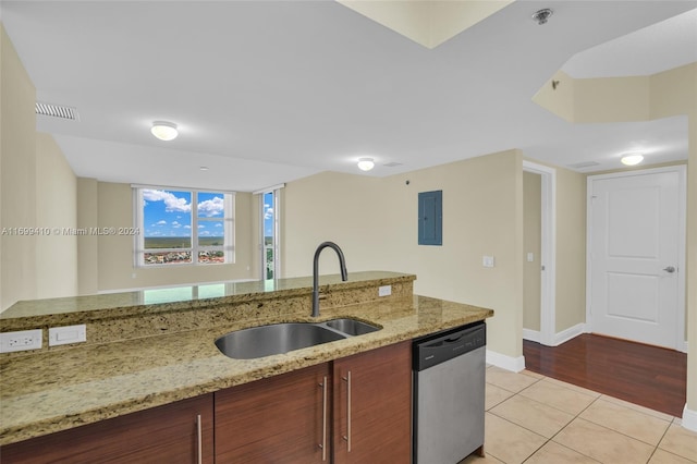 kitchen featuring light stone countertops, light hardwood / wood-style flooring, stainless steel dishwasher, and sink