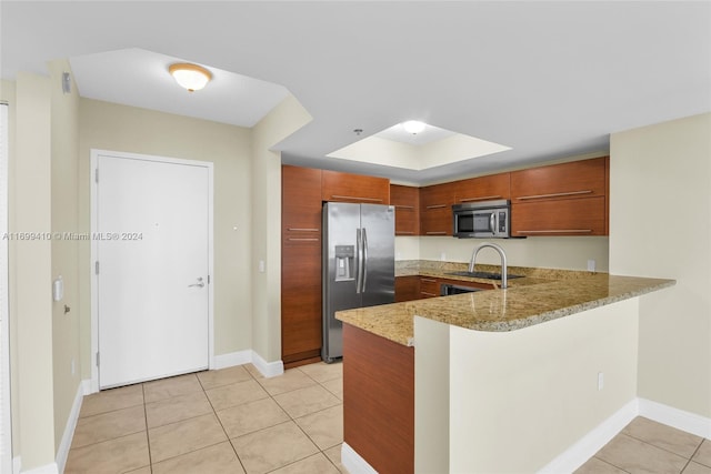 kitchen featuring kitchen peninsula, light tile patterned floors, stainless steel appliances, and light stone countertops